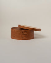 Detail view of the Rikke Falkow Large Cherry Wood Oval Box on light color background.