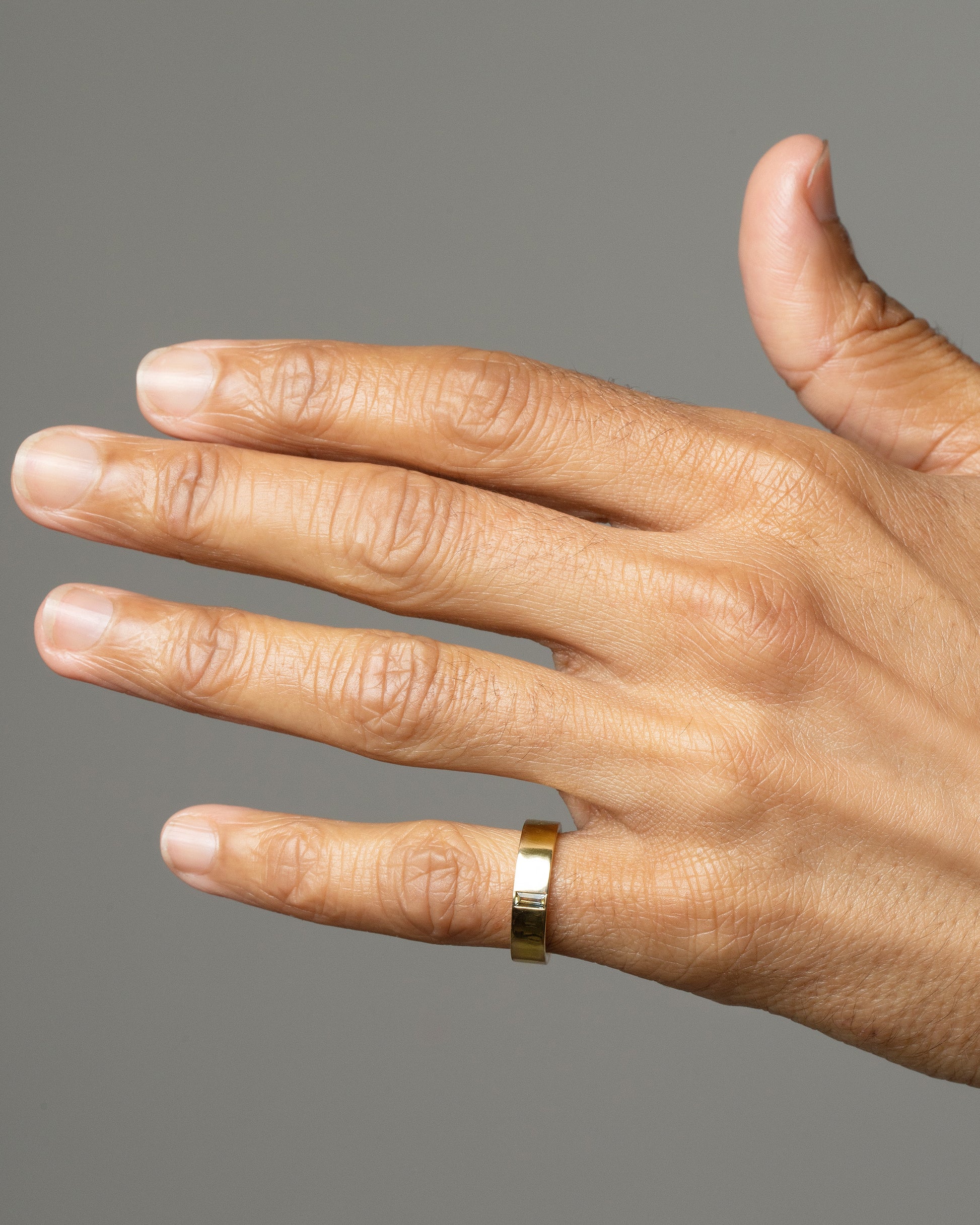 Gold Montana Bicolor Sapphire North South 5mm Baguette-Set Piet Band on male model.