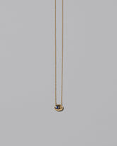 Gold Bicolor Blue Sapphire Level Necklace on light color background.