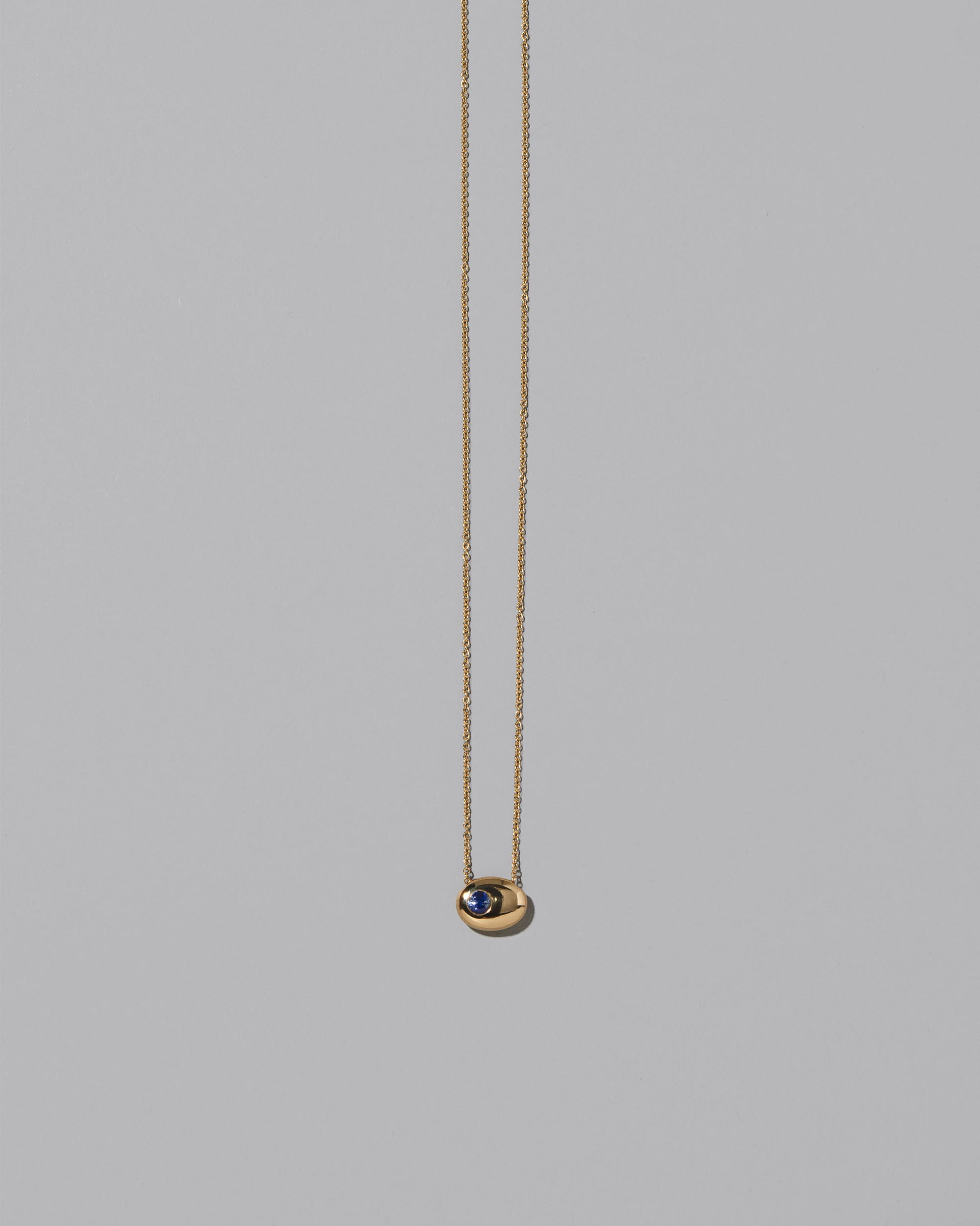 Gold Bicolor Blue Sapphire Level Necklace on light color background.