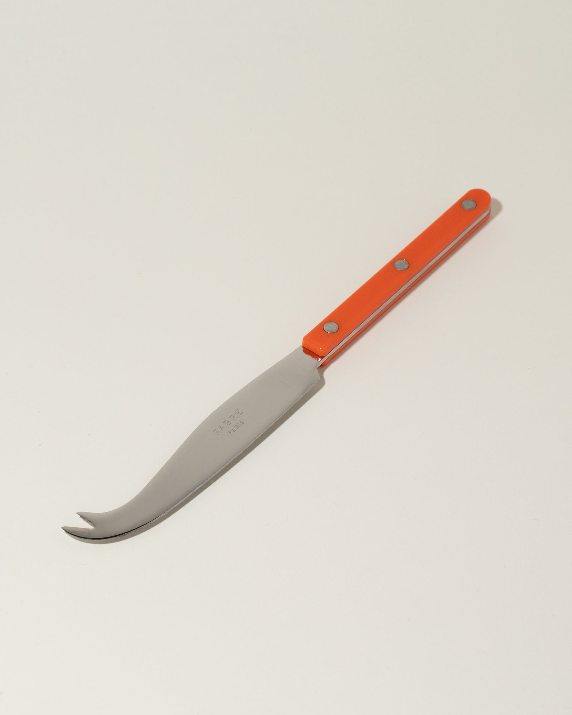 Sabre Paris Orange Cheese Knife on light color background.