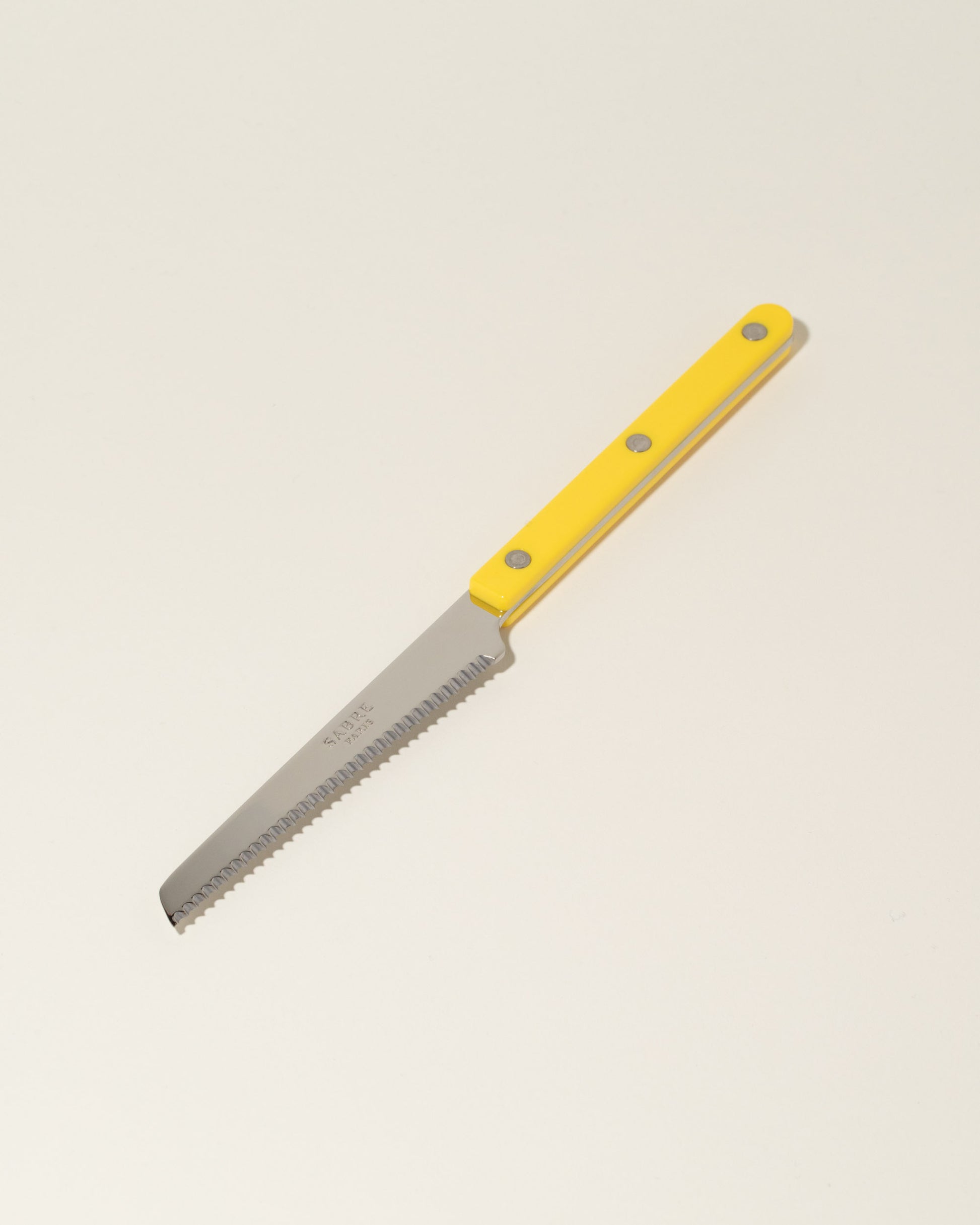 Sabre Paris Yellow Tomato Knife on light color background.