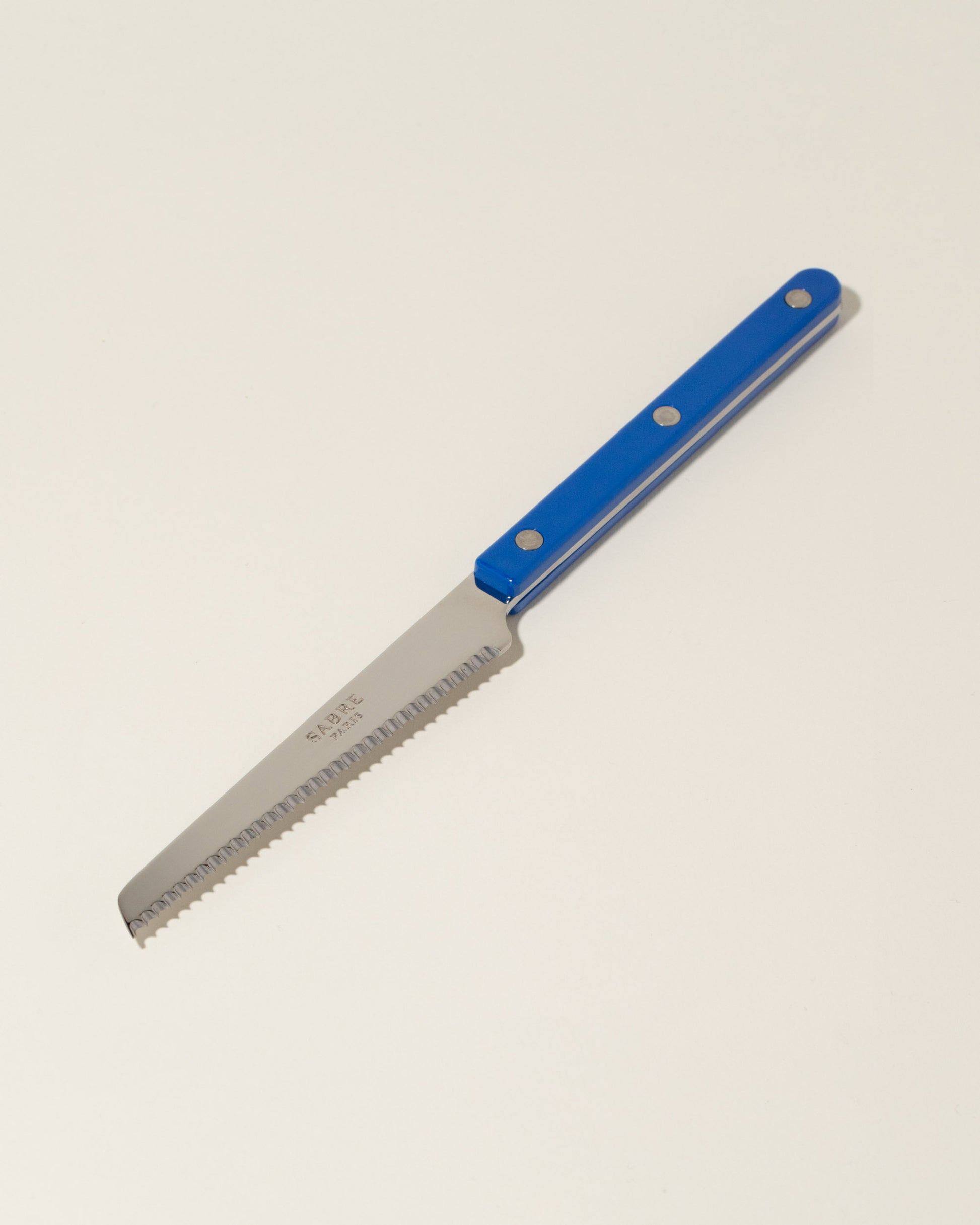 Sabre Paris Lapis Blue Tomato Knife on light color background.