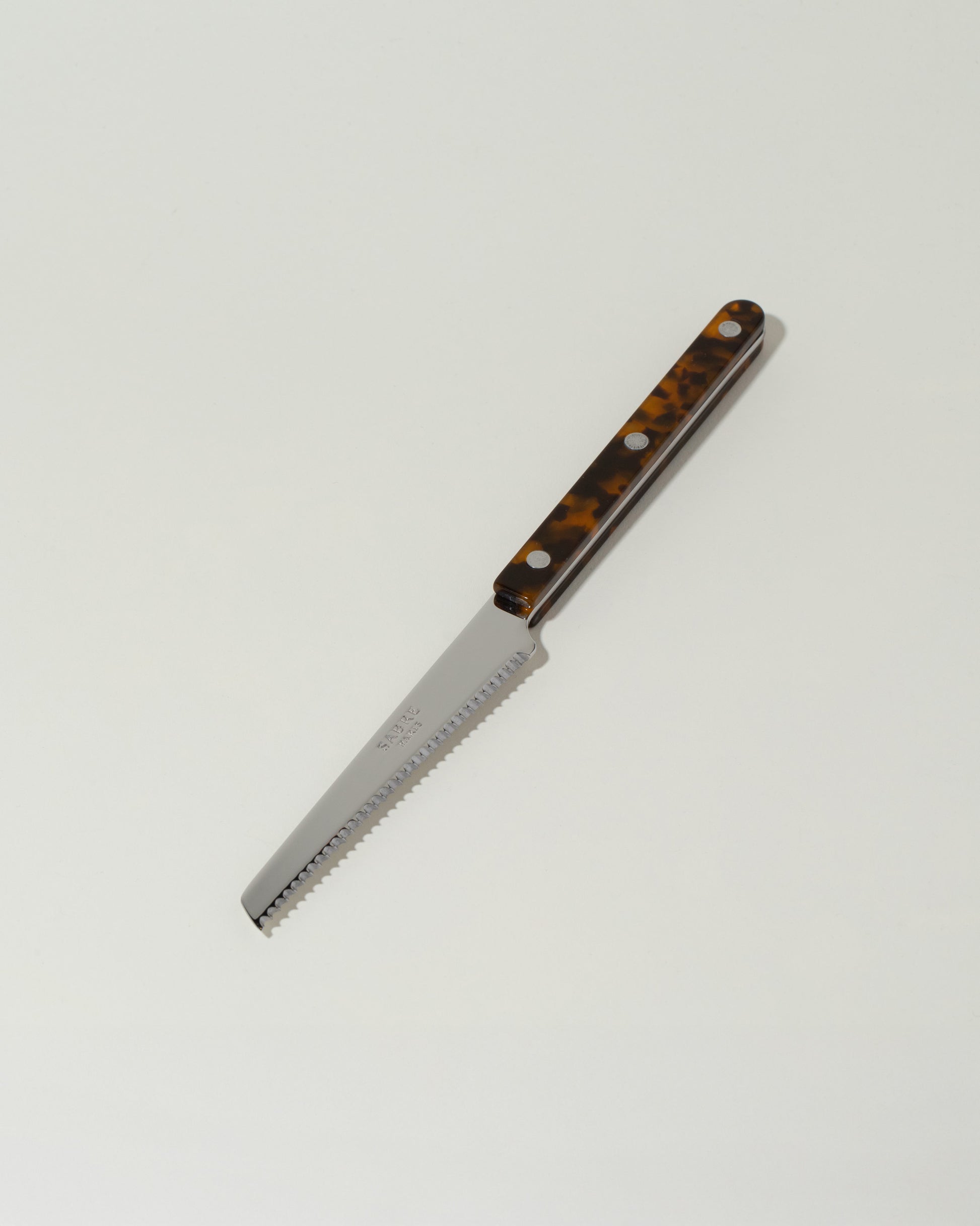Sabre Paris Faux Tortoise Tomato Knife on light color background.