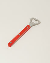 Sabre Paris Red Bottle Opener on light color background.