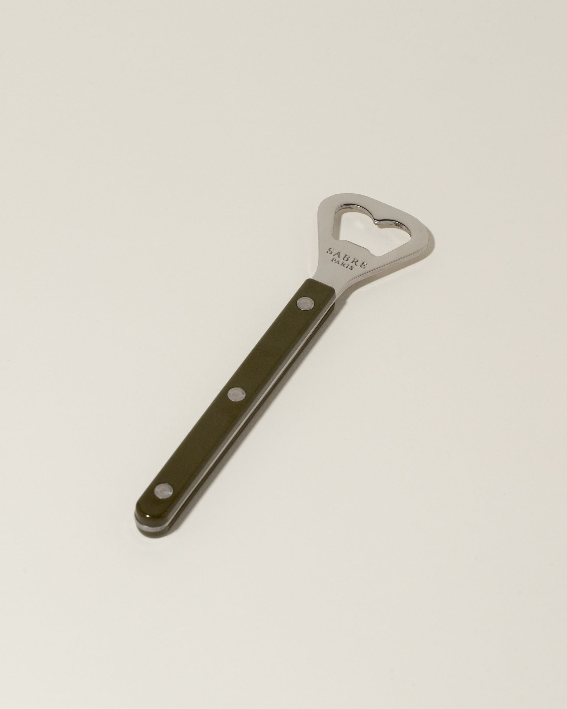 Sabre Paris Green Fern Bottle Opener on light color background.