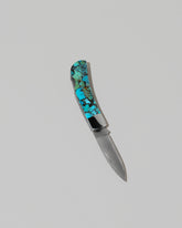 Santa Fe Stoneworks Kingmen Turquoise Lockback Knife on light color background.
