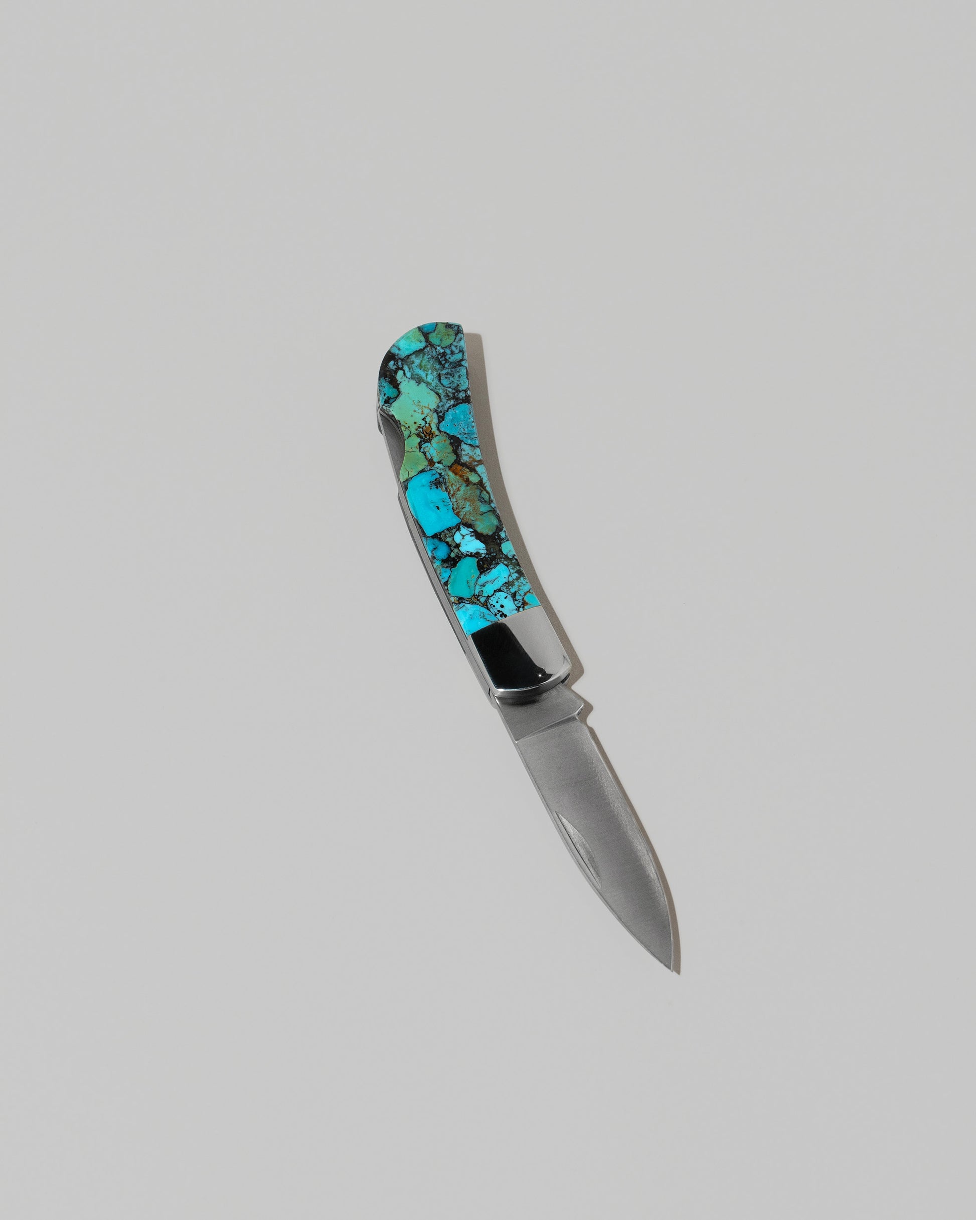Santa Fe Stoneworks Kingmen Turquoise Lockback Knife on light color background.