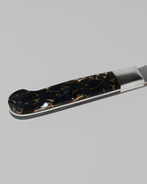Closeup details of the Santa Fe Stoneworks Black Buffalo Turquoise Bread Knife on light color background.