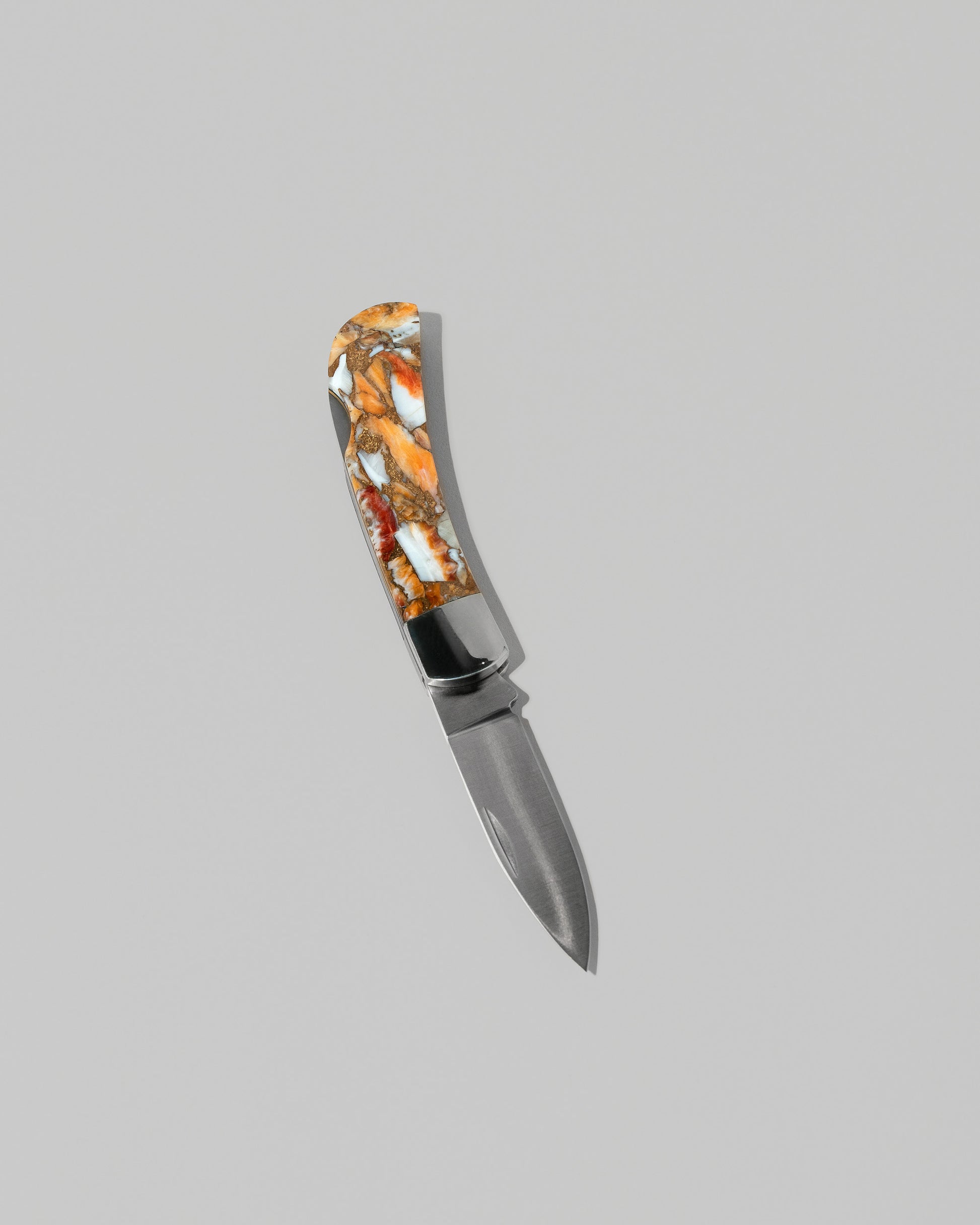Santa Fe Stoneworks Spiney Oyster Small Lockback Knife on light color background.