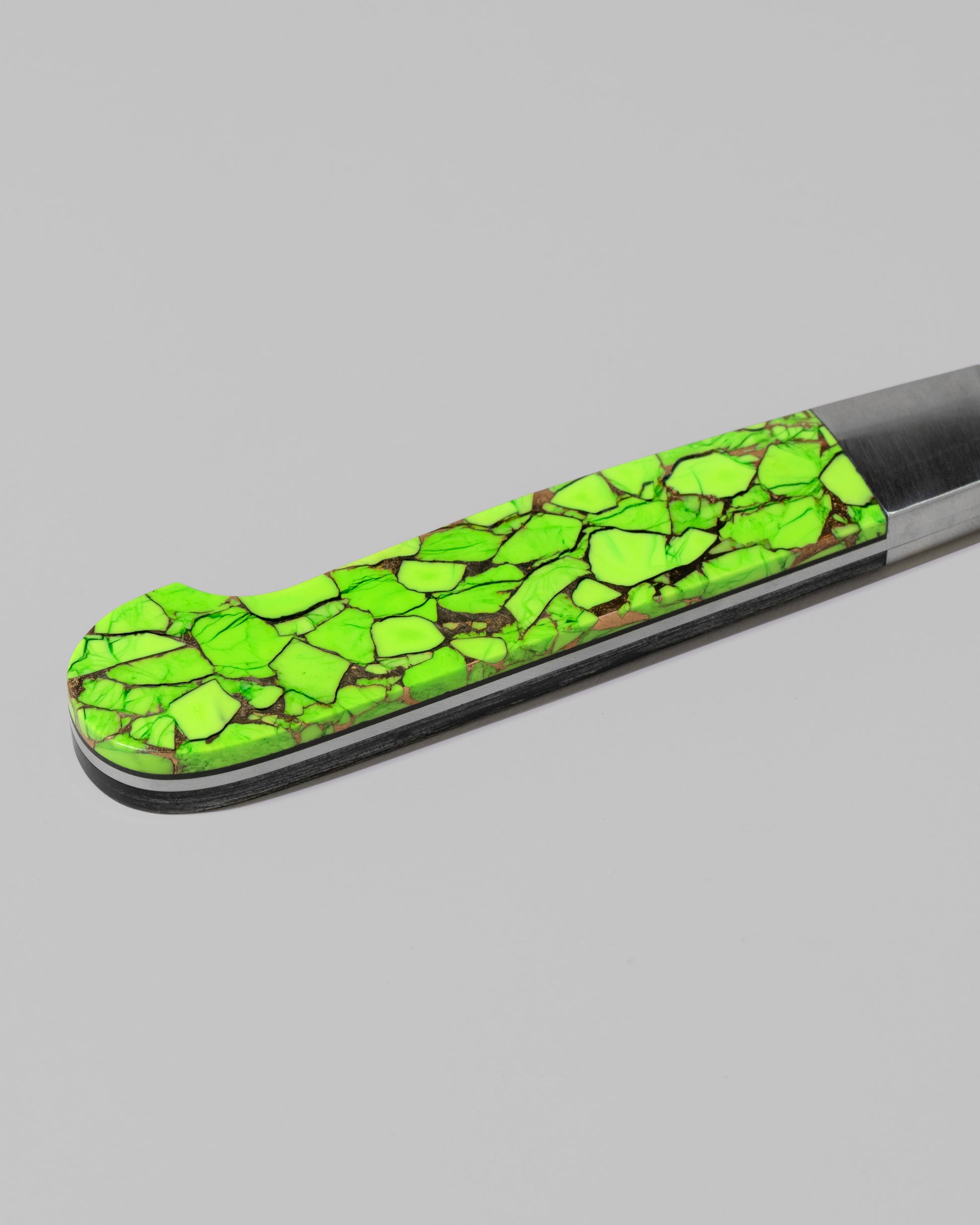 Closeup details of the Santa Fe Stoneworks Neon Ranger Bread Knife on light color background.