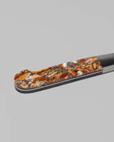 Closeup details of the Santa Fe Stoneworks Spiney Oyster Bread Knife on light color background.