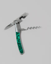 Detail view of the Santa Fe Stoneworks Tru Stone Malachite Waiter's Knife on light color background.