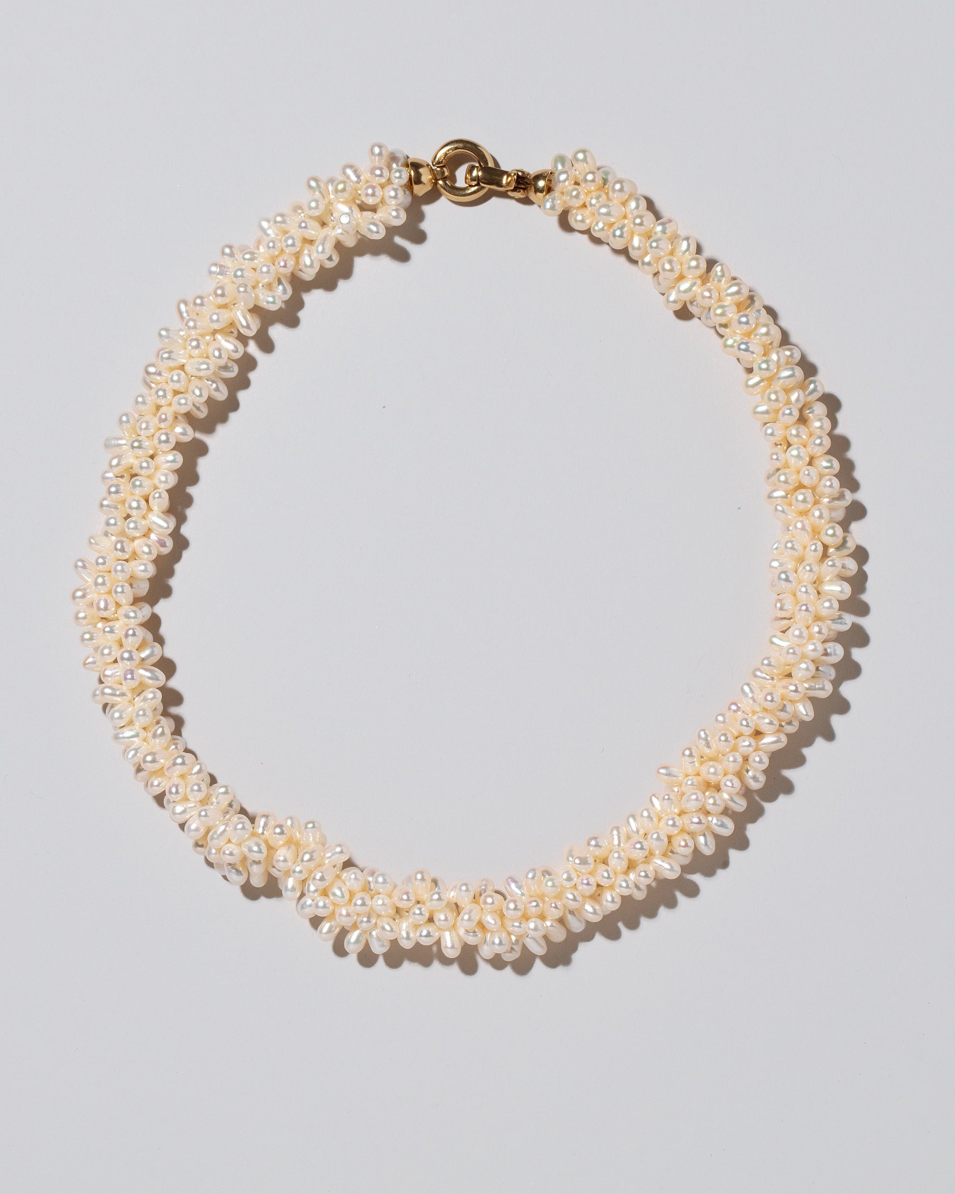 Fold Over Toggle Clasp Braided Zipper Pearl Collar Necklace on light color background.