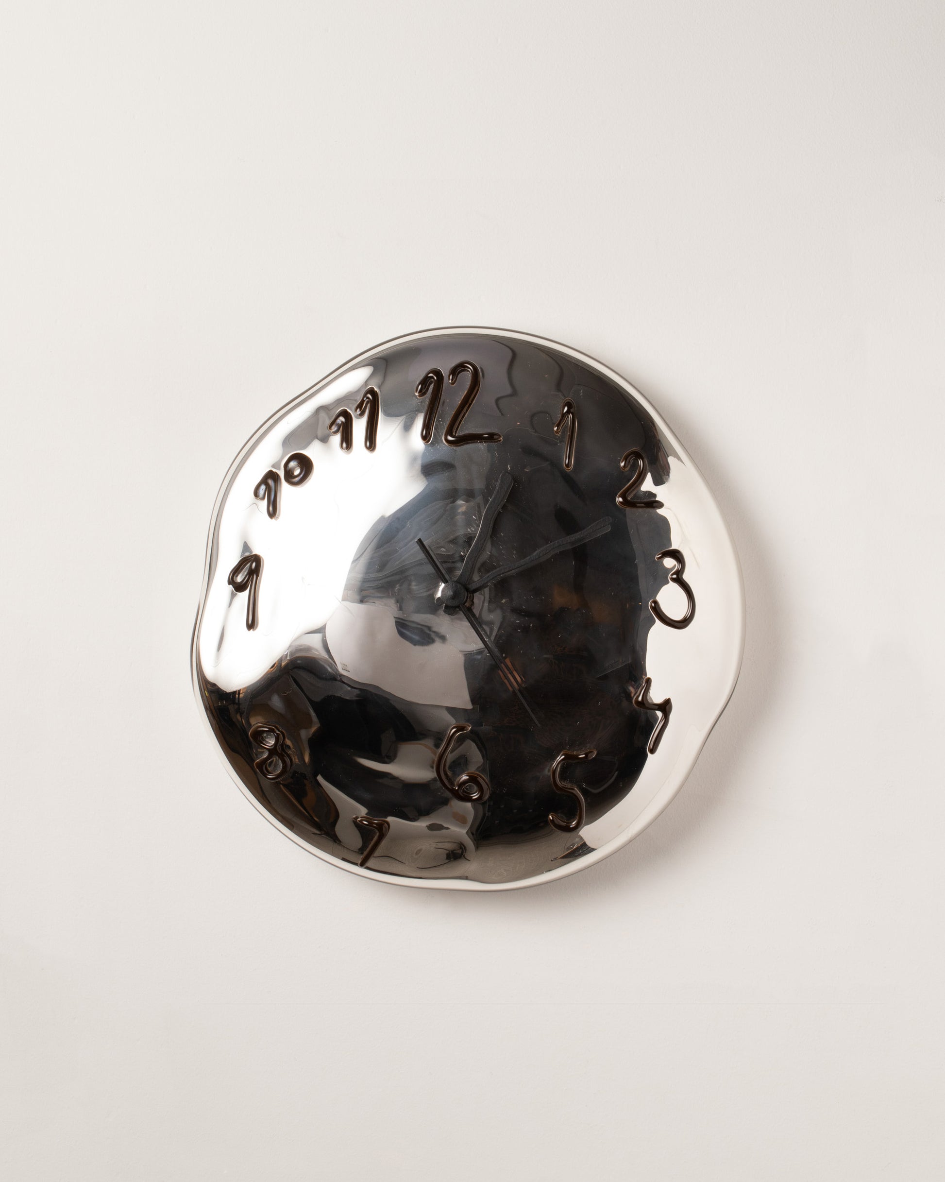 Silje Lindrup Black Hands One Brown Glass Wall Clock on light color background.