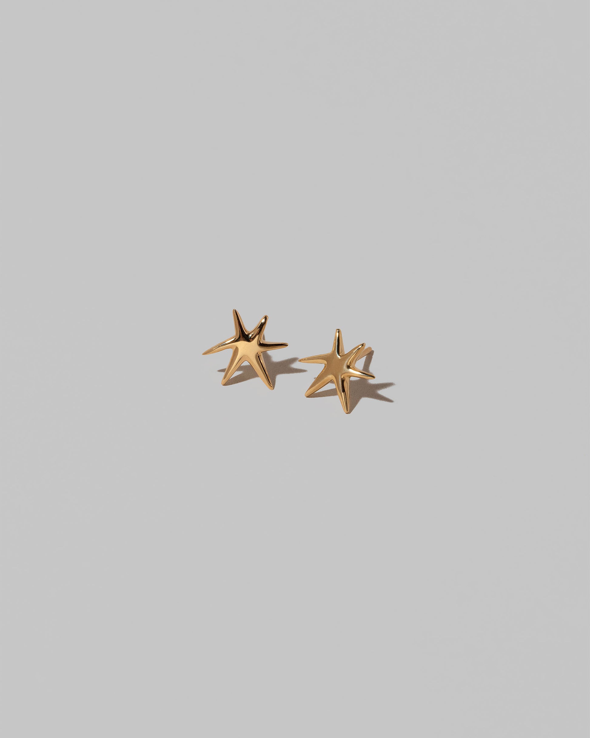 Shape One Small Verve Six Point Star Stud Earrings on light color background.