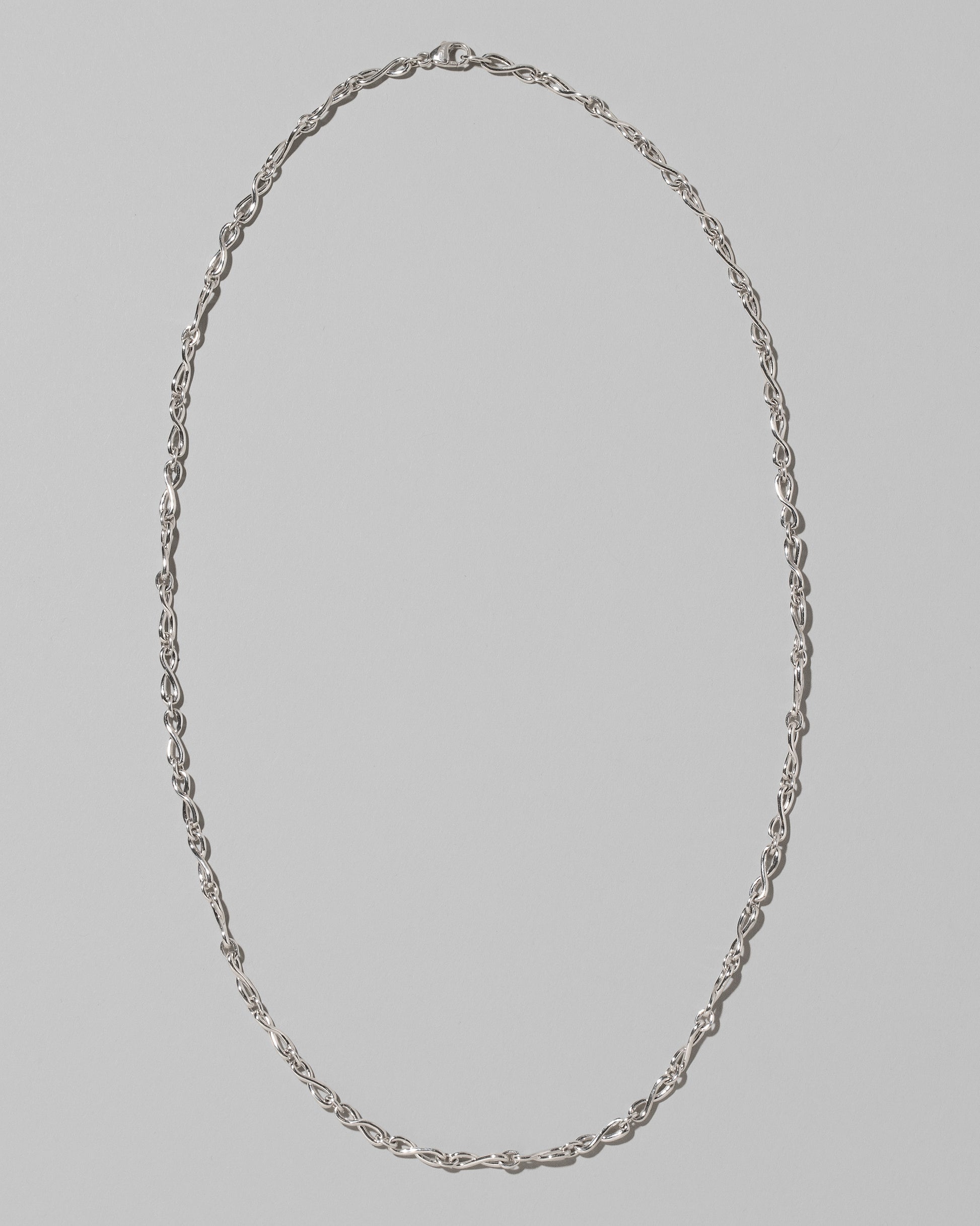 CRZM Sterling Silver Infinity Chain Necklace on light color background.