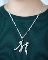 CRZM Sterling Silver Infinity Chain Necklace and CRZM Letter M Large Sterling Silver Letter Charm on model.
