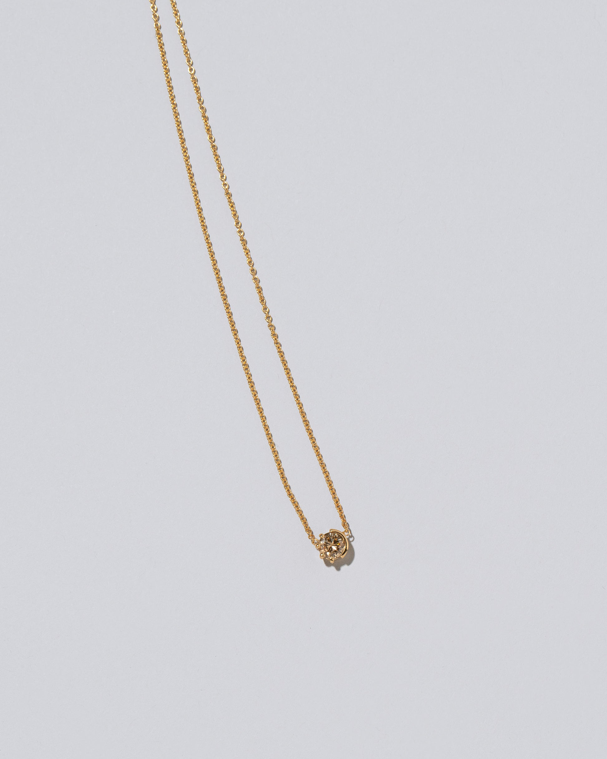 Champagne Diamond Sun & Moon Necklace on light color background.