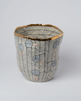 Closeup details of the Suzanne Sullivan Alethiometer Stripe Tapered Vessel on light color background.