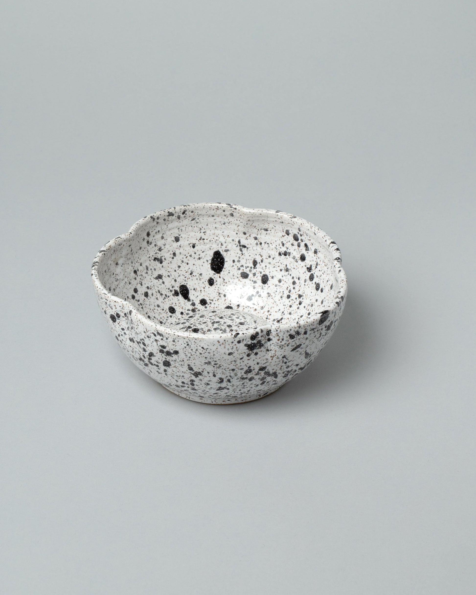 Recreation Center Black Speckle Flower Bowl on light color background.