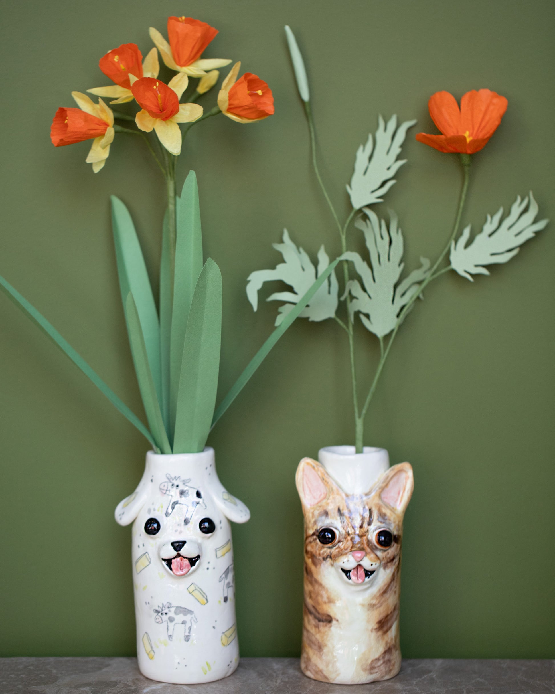 Styled image featuring the The Green Vase Paper Daffodil Stem and Paper California Poppy Stem, with the Katie Kimmel For Your Pleasure Ripley Cat Vase and Tessa Cat Vase.