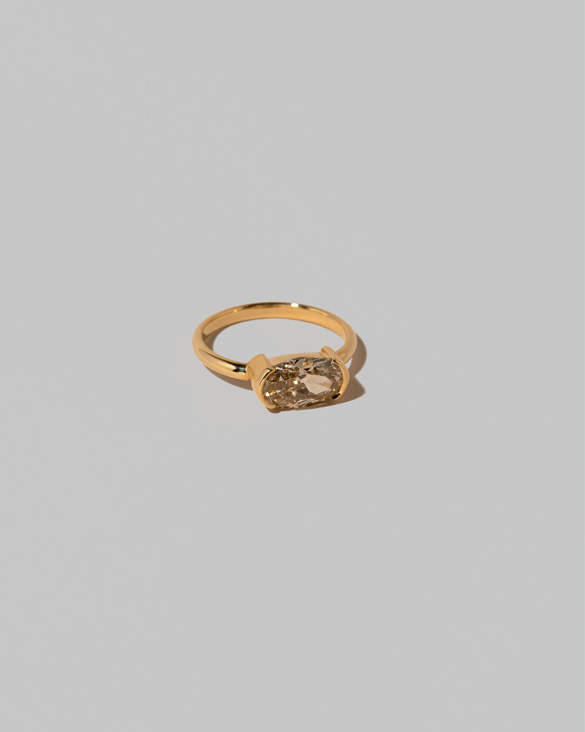 View from the side of the Oval Brown Diamond Transformation Ring on light color background.