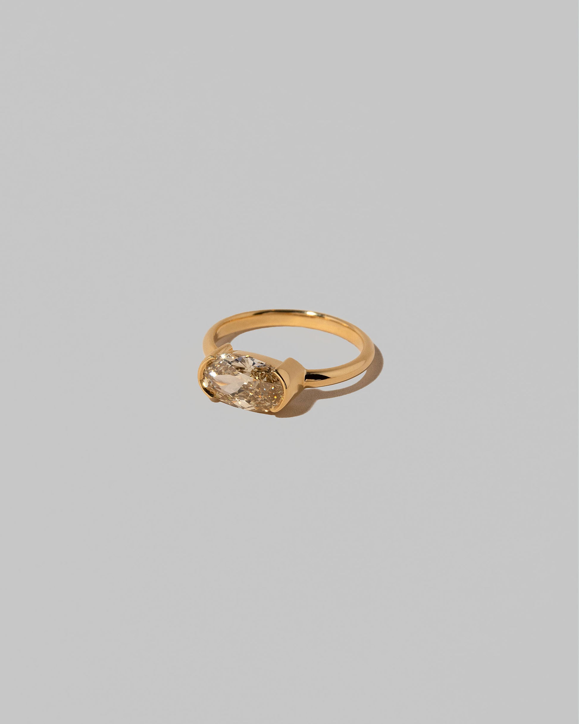 View from the side of the Oval Brown Diamond Transformation Ring on light color background.