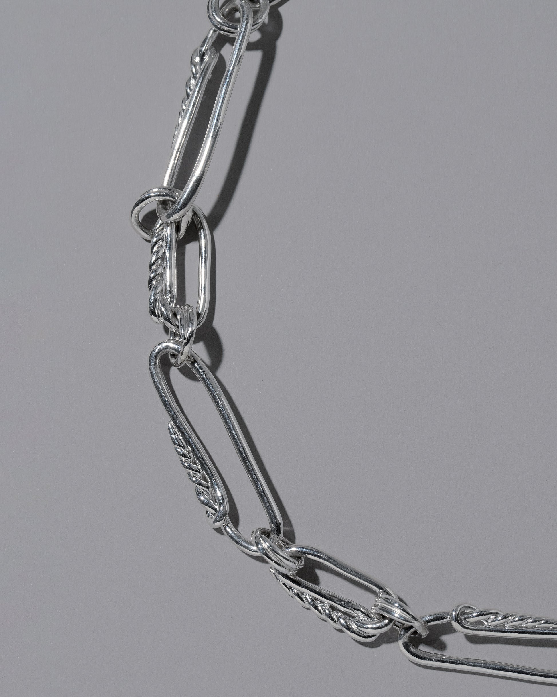 Closeup details of the CRZM Sterling Silver Ophiolite Necklace on light color background.