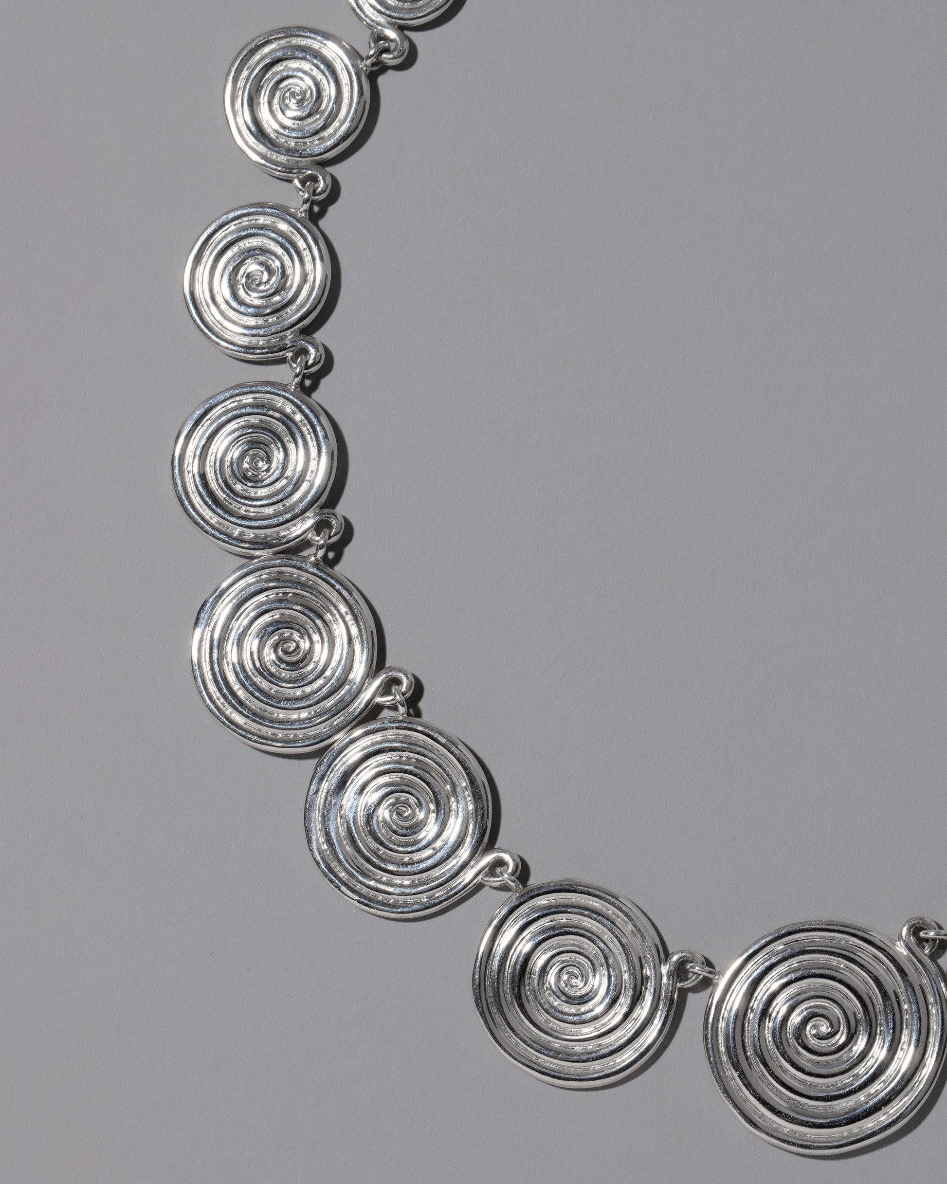 Closeup details of the CRZM Sterling Silver Serpentinite Necklace on light color background.