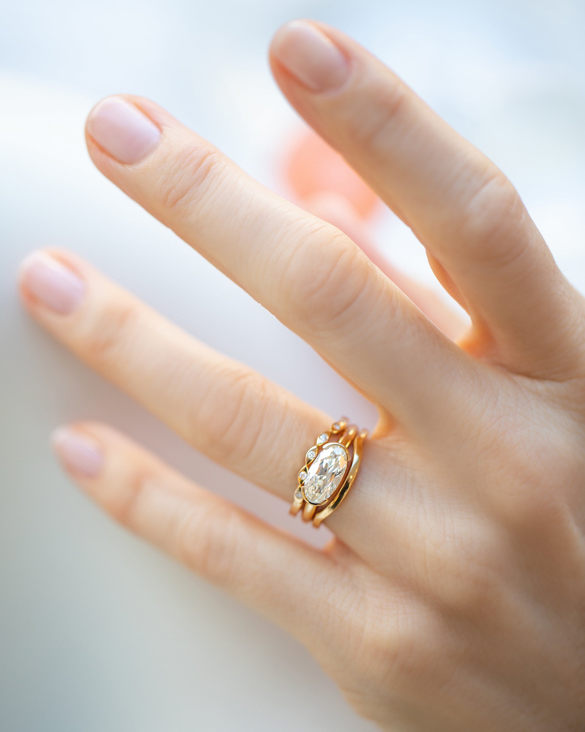 Gold Seeing Eye Band, White Diamond Oval Diamond Transformation Ring and Gold Solid Bow Band on model.