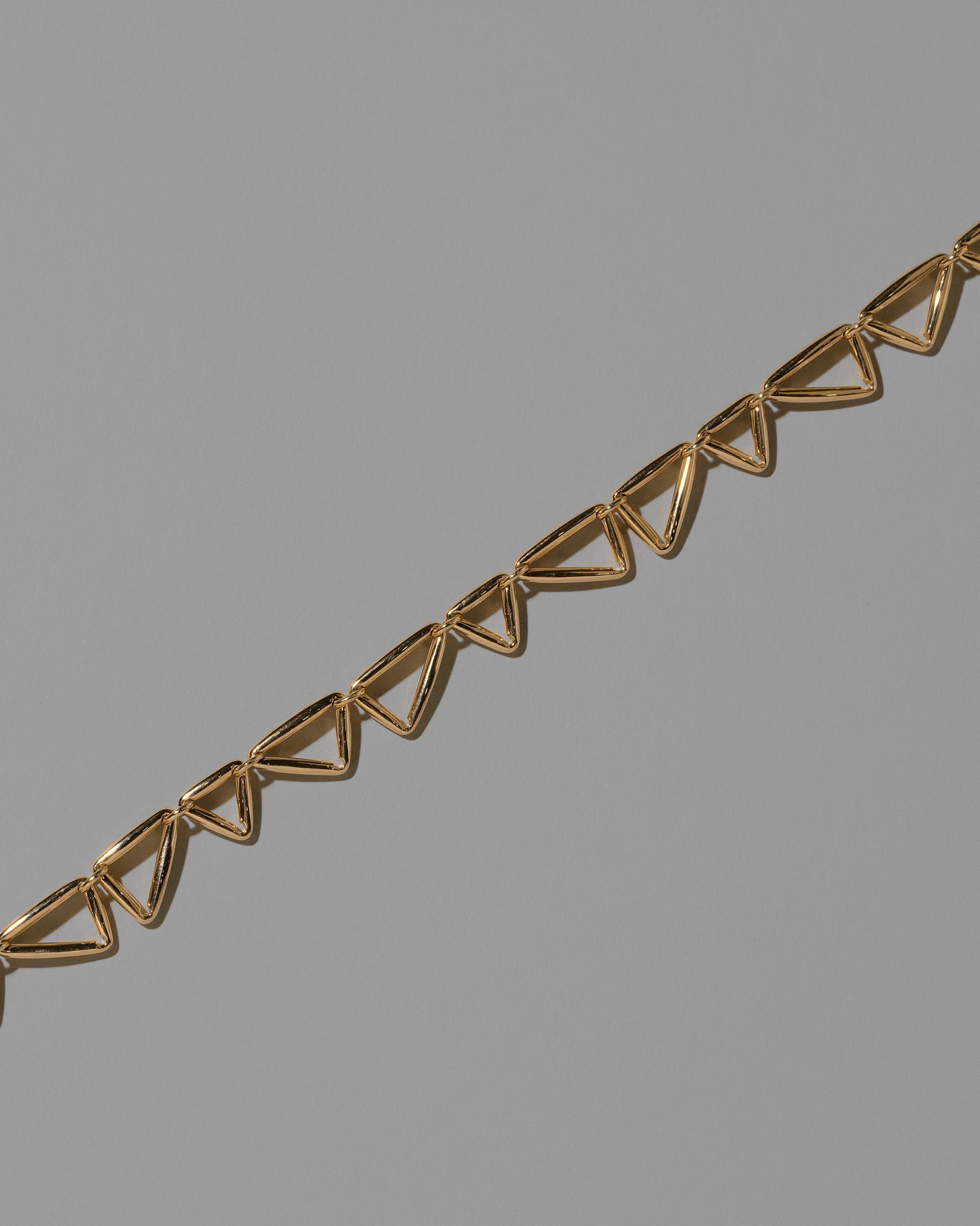 Closeup details of the Gold Flexure Necklace on light color background.