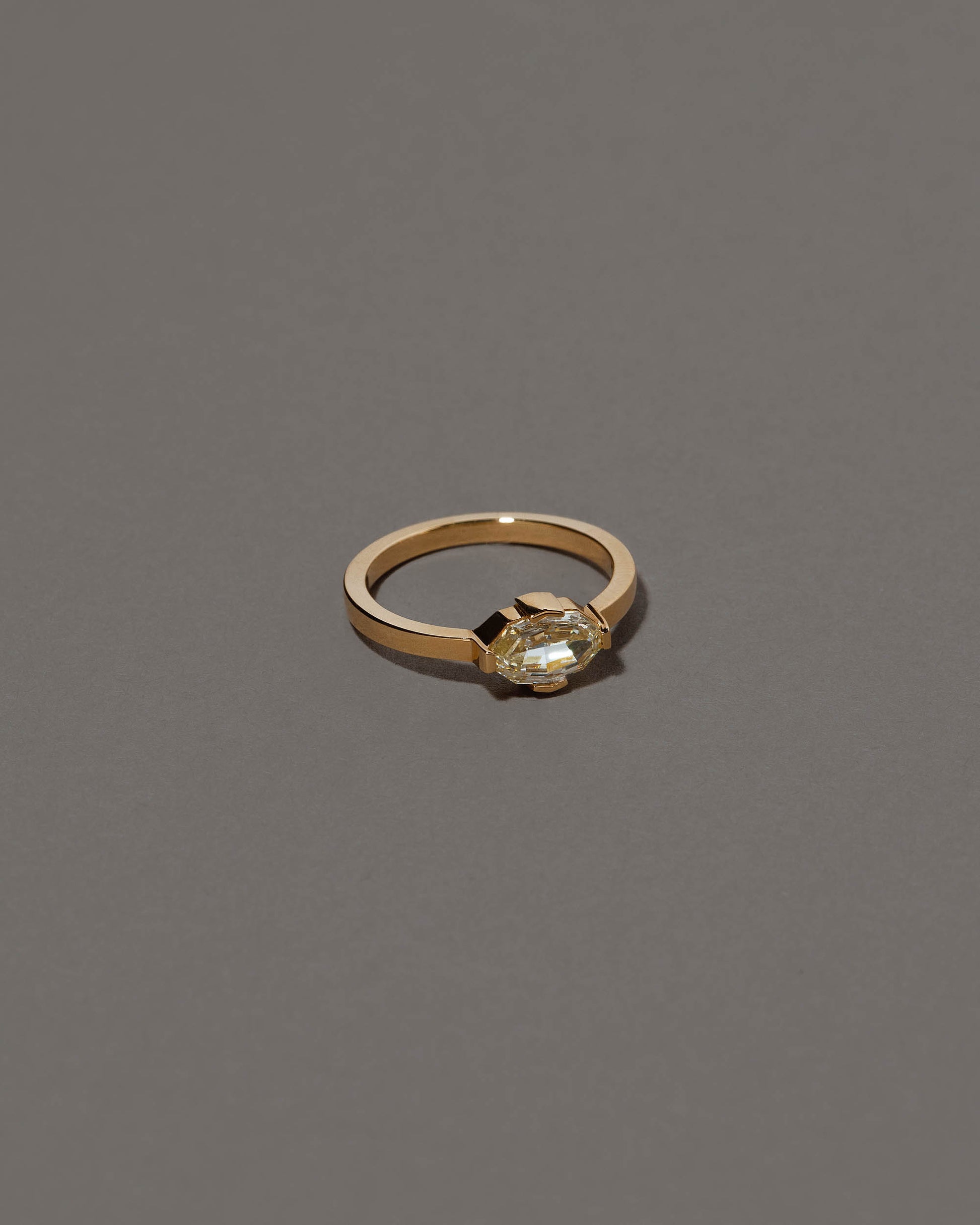 View from the side of the Beholden Ring on grey color background.