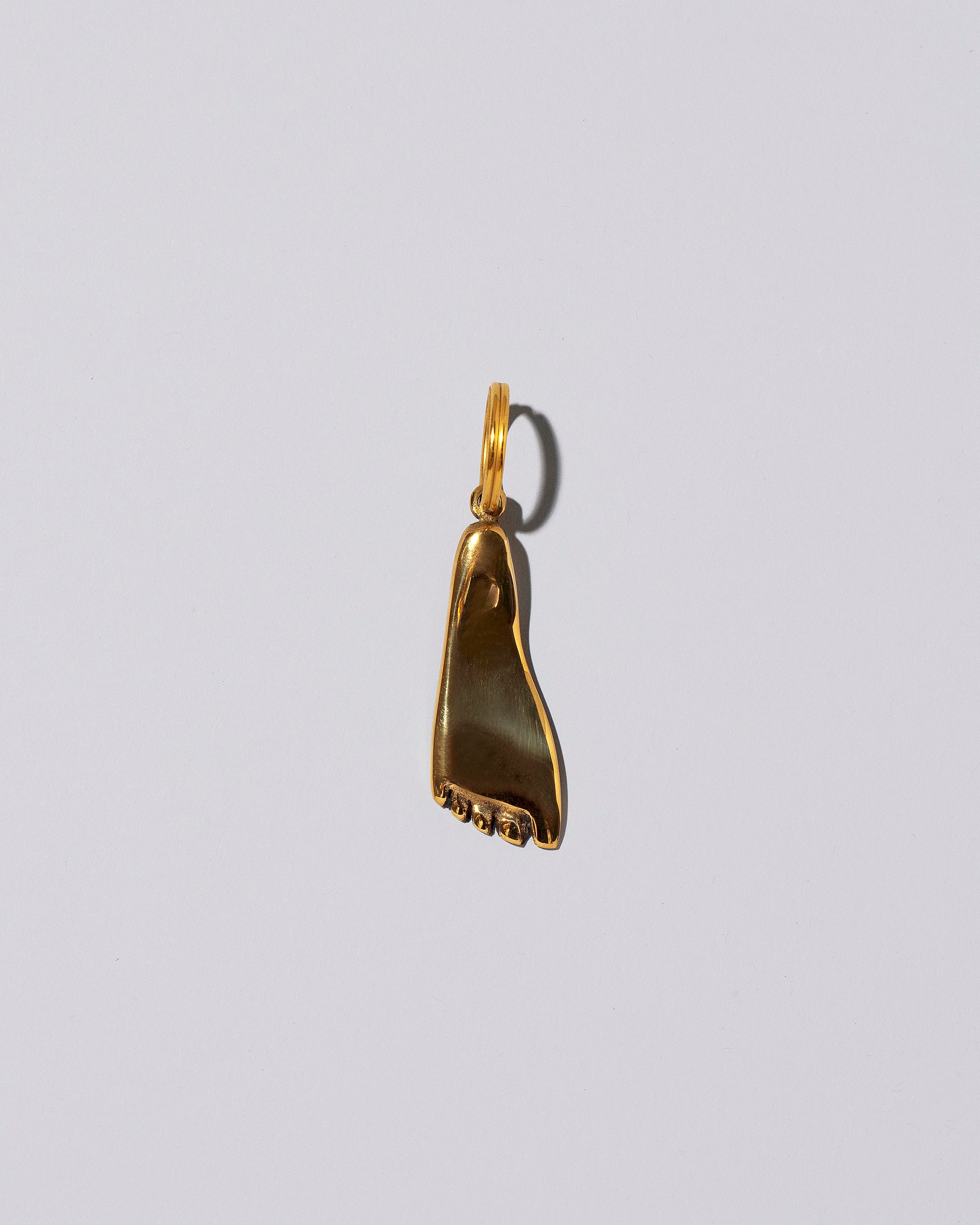 Carl Auböck Brass Foot Keyring on light color background.