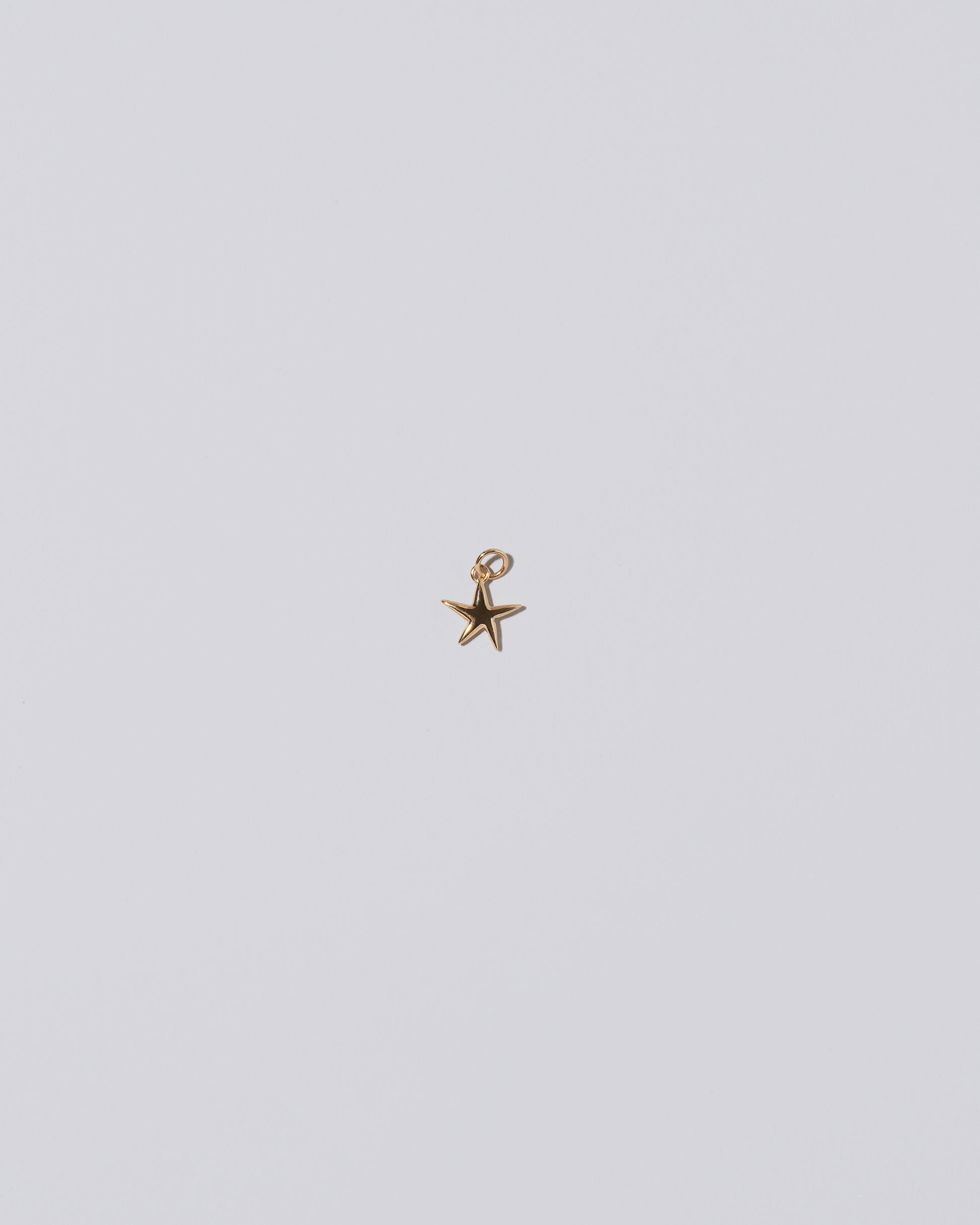 Verve Five Point Star Charm on light color background.