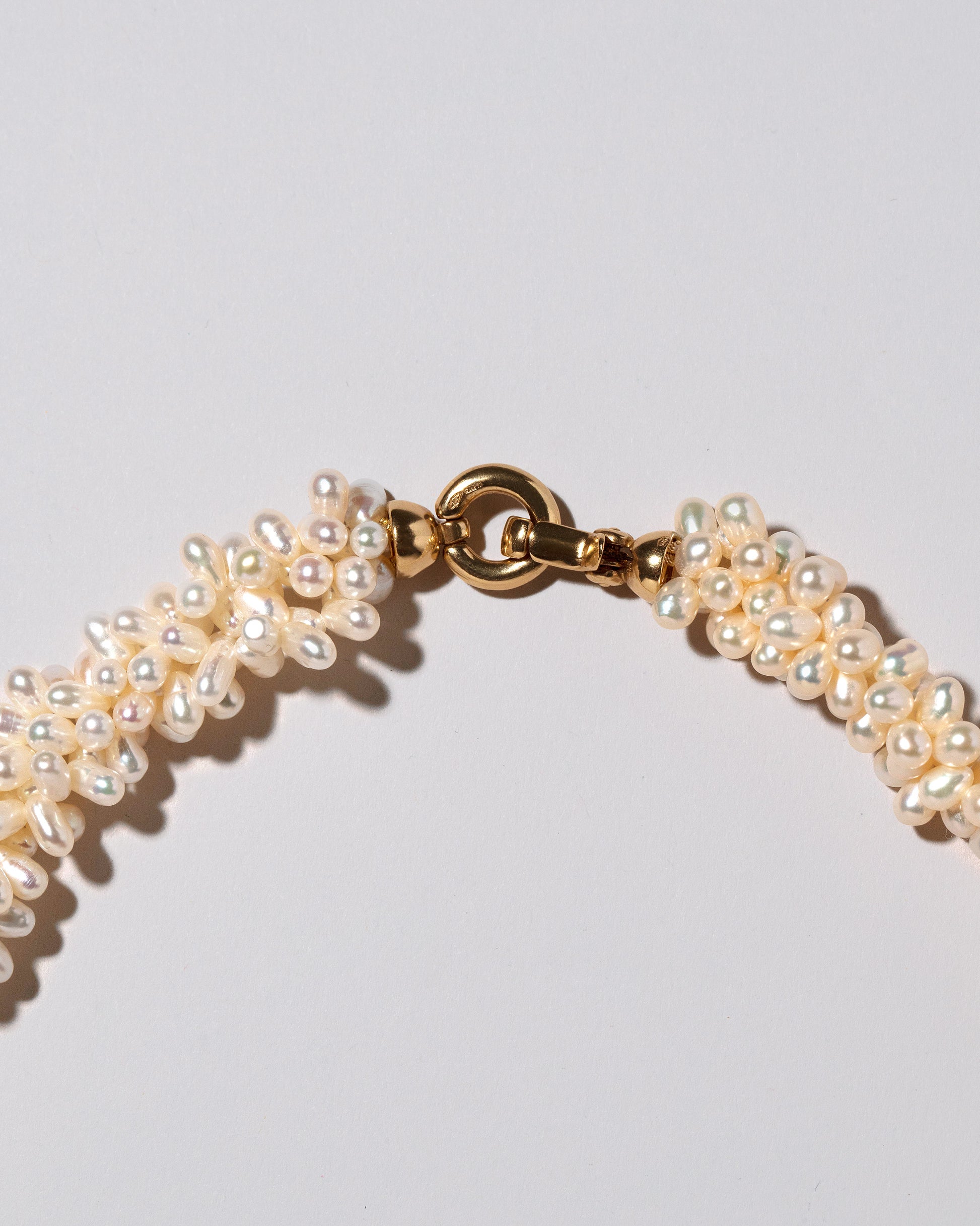 Fold Over Toggle Clasp Braided Zipper Pearl Collar Necklace on light color background.