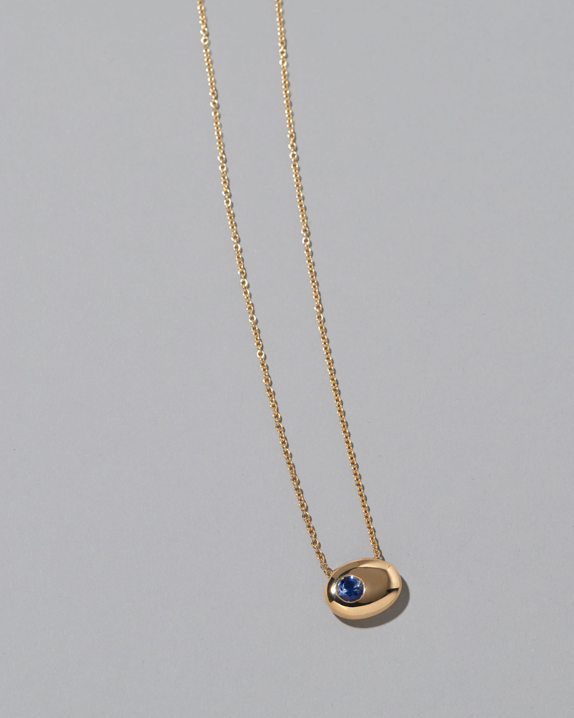 Gold Bicolor Blue Sapphire Level Necklace on light color background.