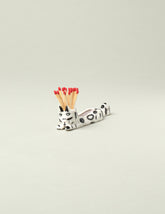 Eleonor Boström Black Spots Matchstick Cat on light color background.