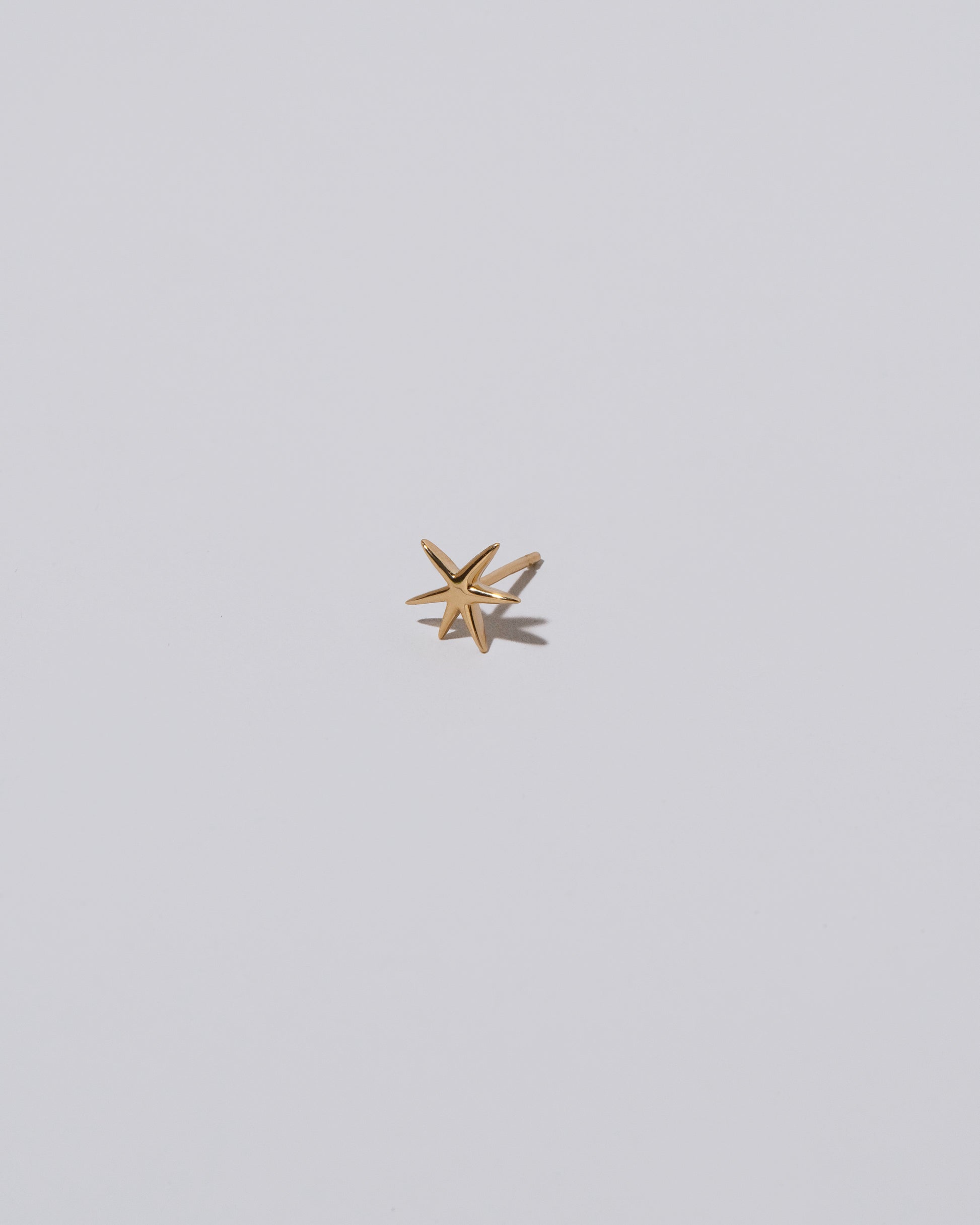 Shape Two Small Verve Six Point Star Stud Earring single on light color background.