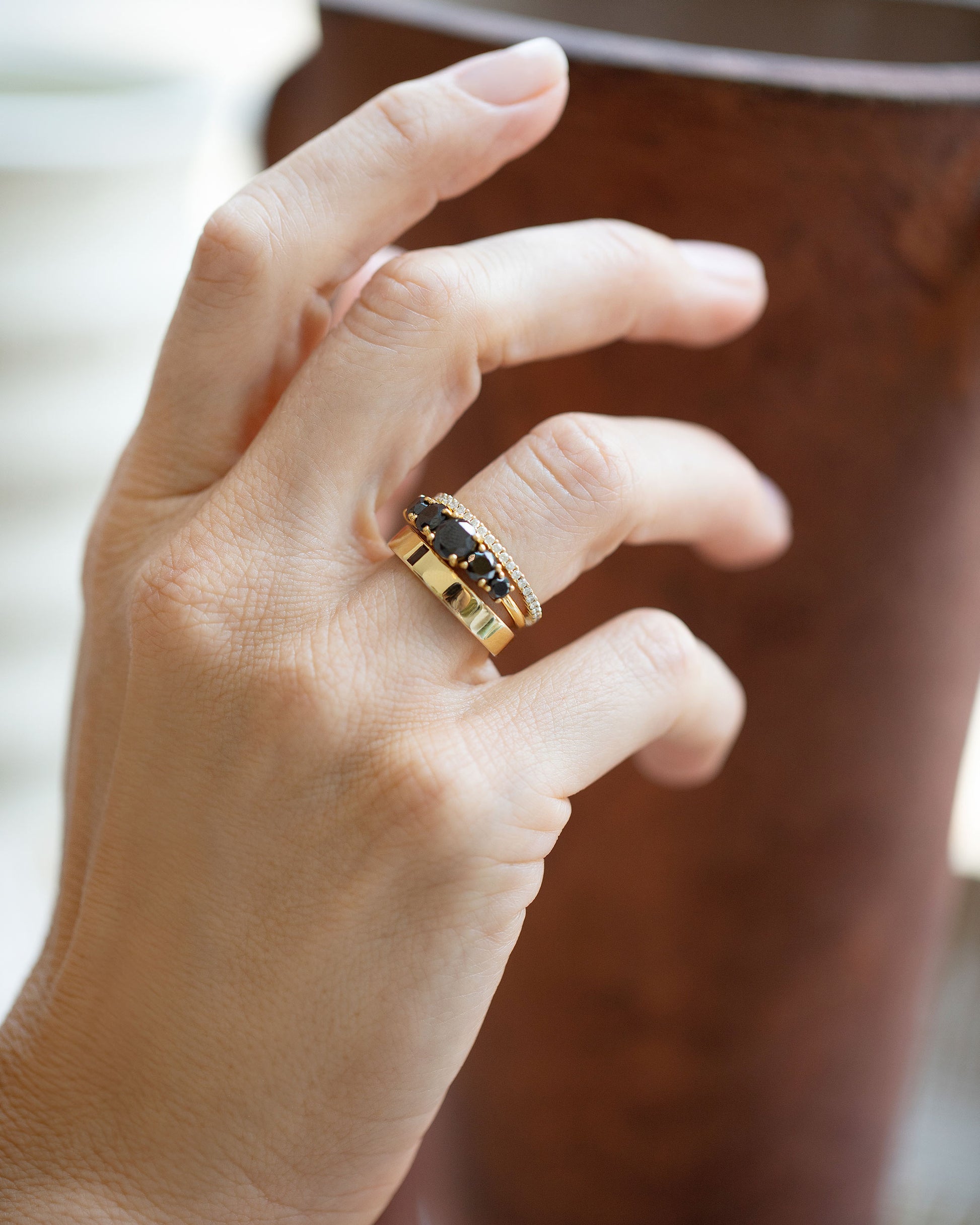 Styled image featuring the Gold Andalusite North South 4mm Baguette-Set Piet Band, Prism Ring and Gold White Diamond Gear Edge Band on model.