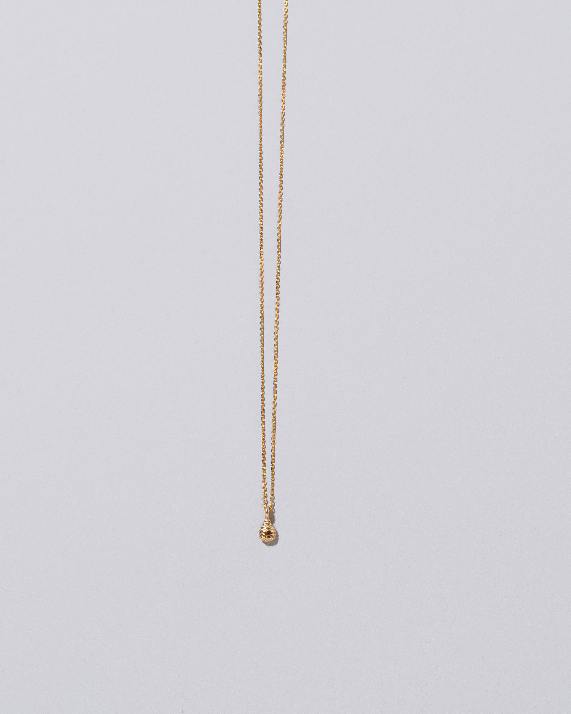 Tear Talisman Pendant Necklace on light color background.