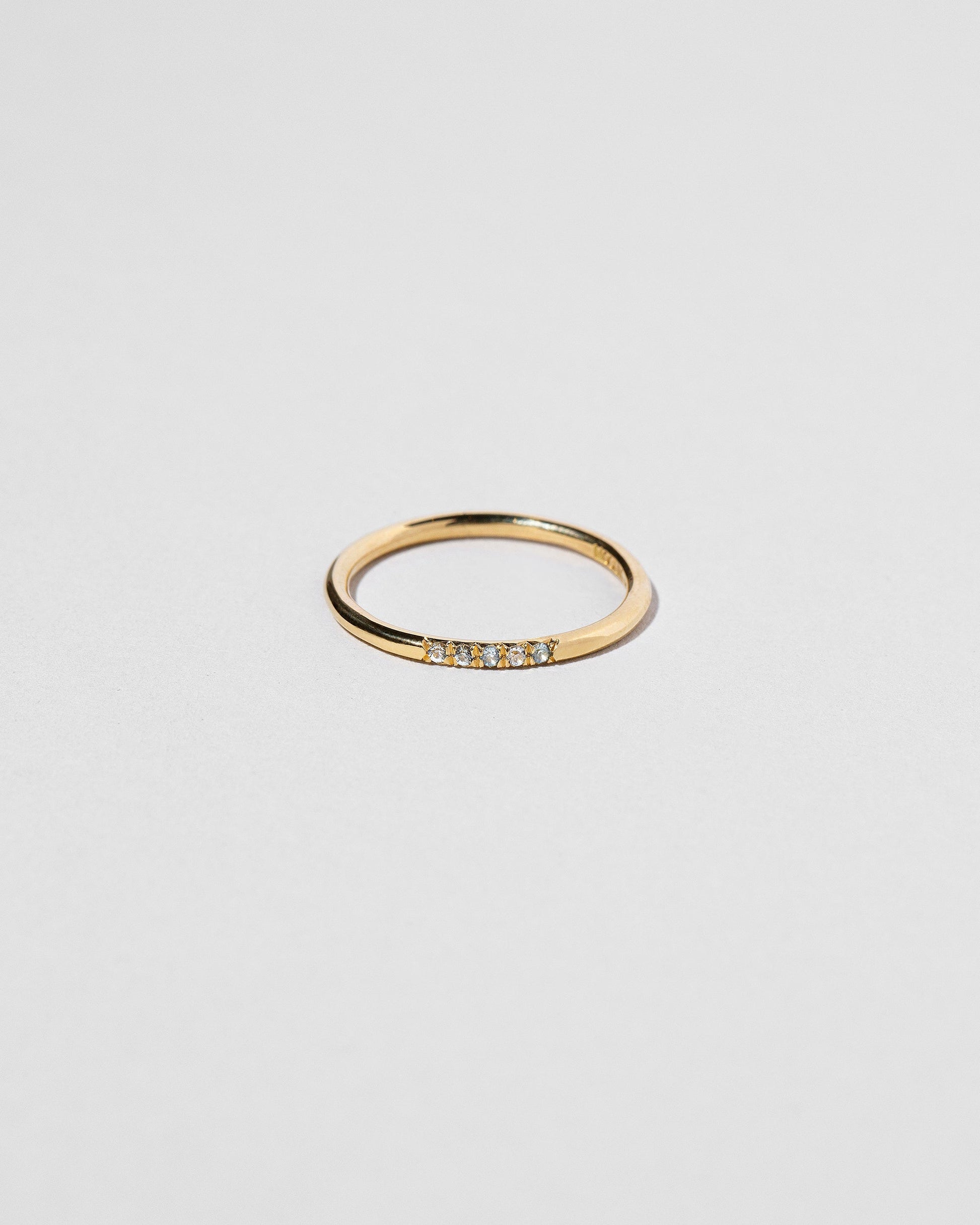 Gold Five Stone Blue Sapphire Dot Band on light color background.