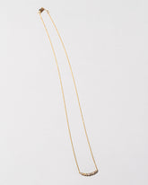 White Diamond Crescent Necklace on light color background.