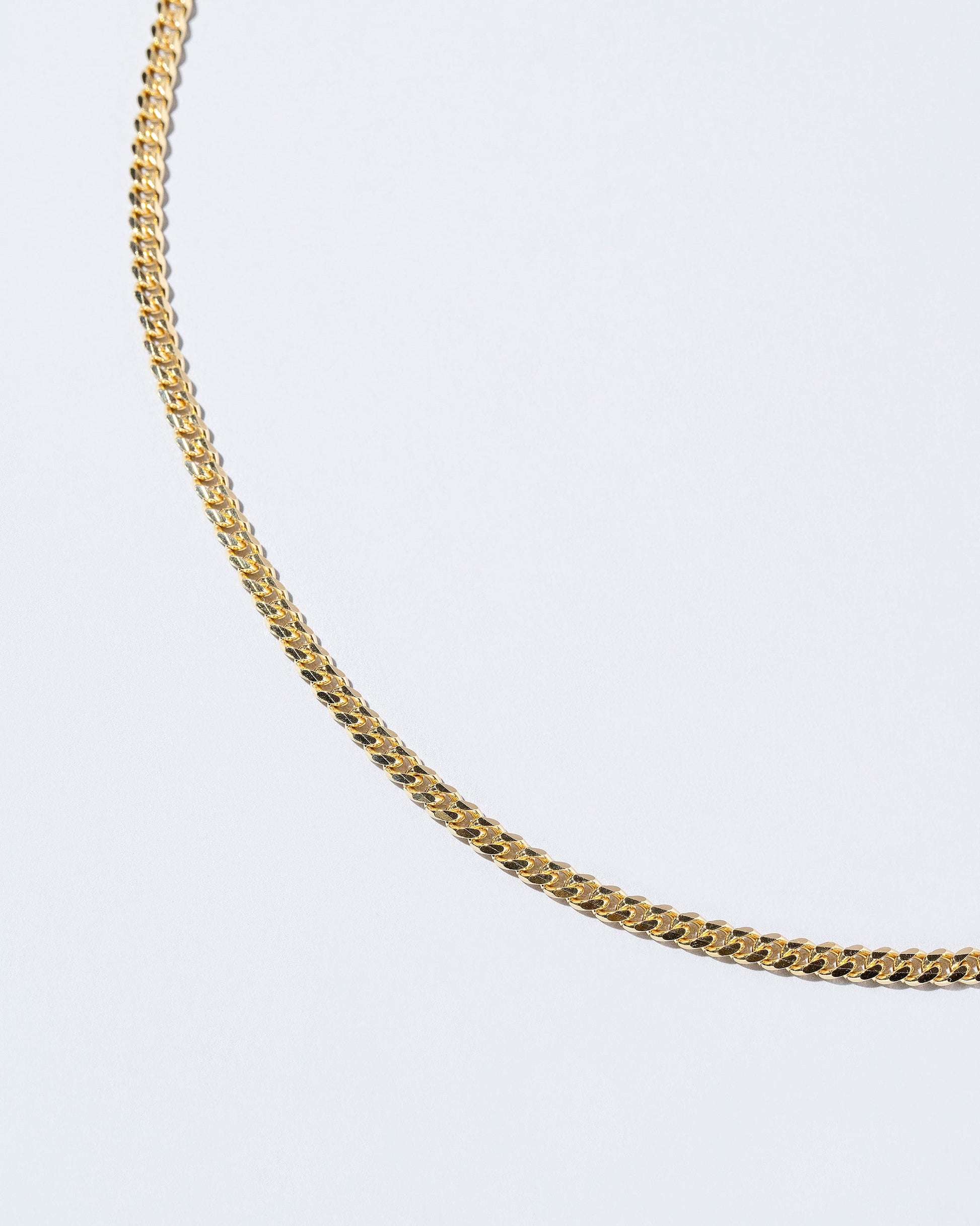 Closeup details of the 3.4mm Curb Chain Necklace on light color background.