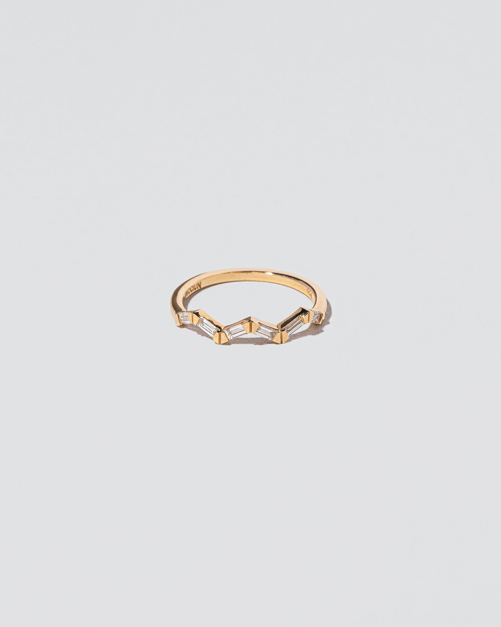 White Diamond Baguette Yellow Gold Zig Zag Band on light color background.