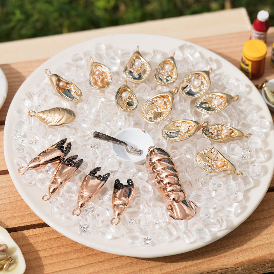product_details::Styled image featuring the Lobster Tail Charm, Clam on Half Shell Charm and Stone Crab Claw Charm.