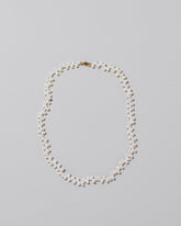 Small Zipper Pearl Necklace on light color background.
