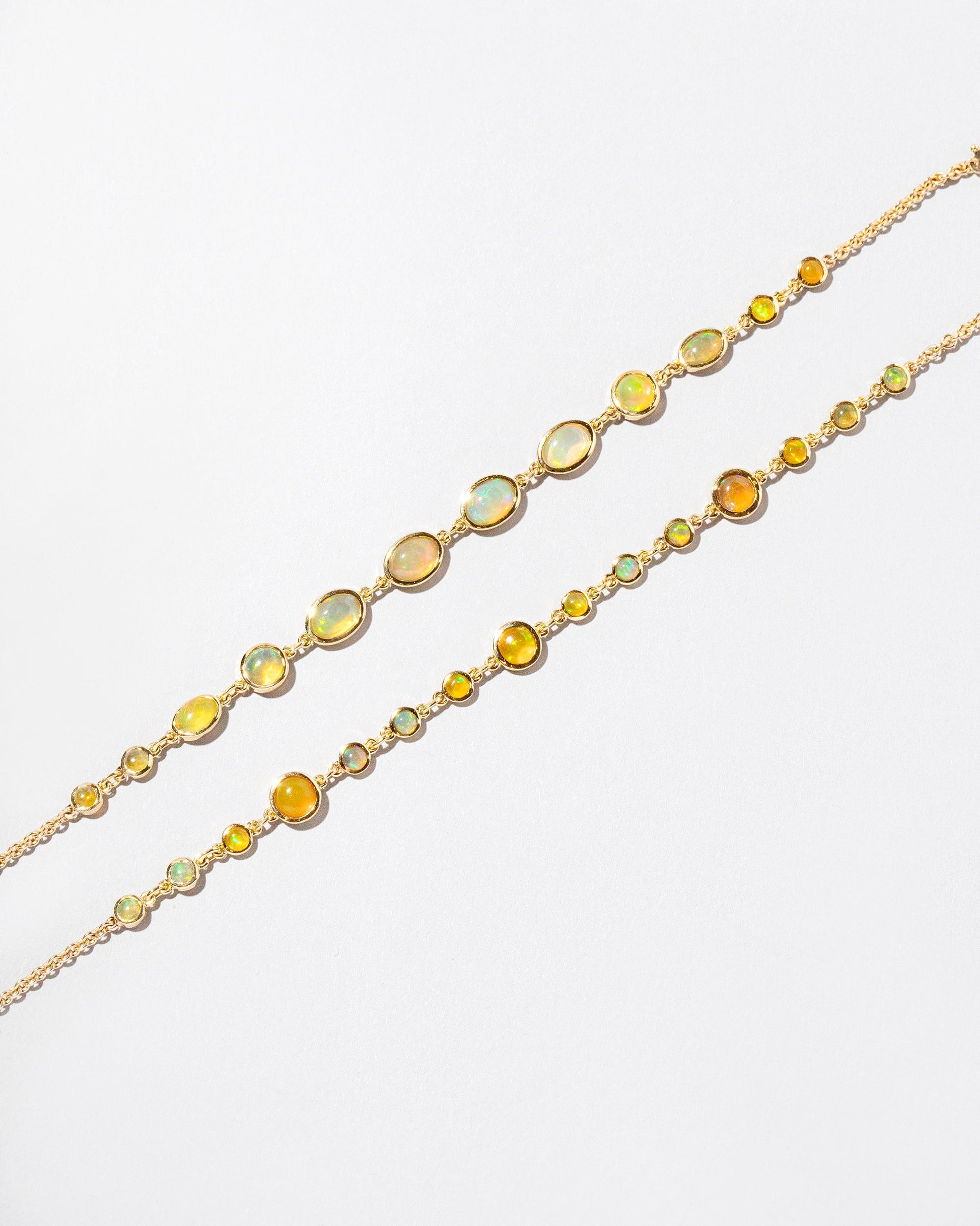  Ops Bracelet and Saturn Bracelet on light color background.