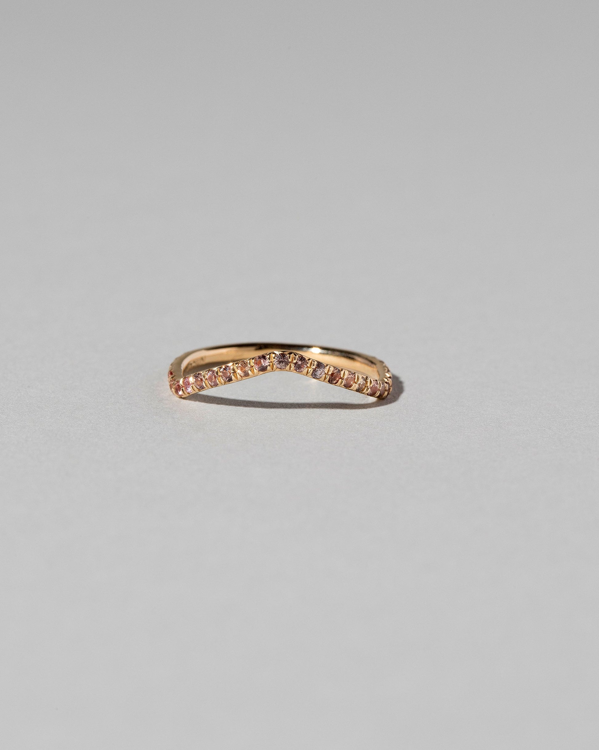 Gold Pavé Peach Sapphire Low Peak Band on light color background.