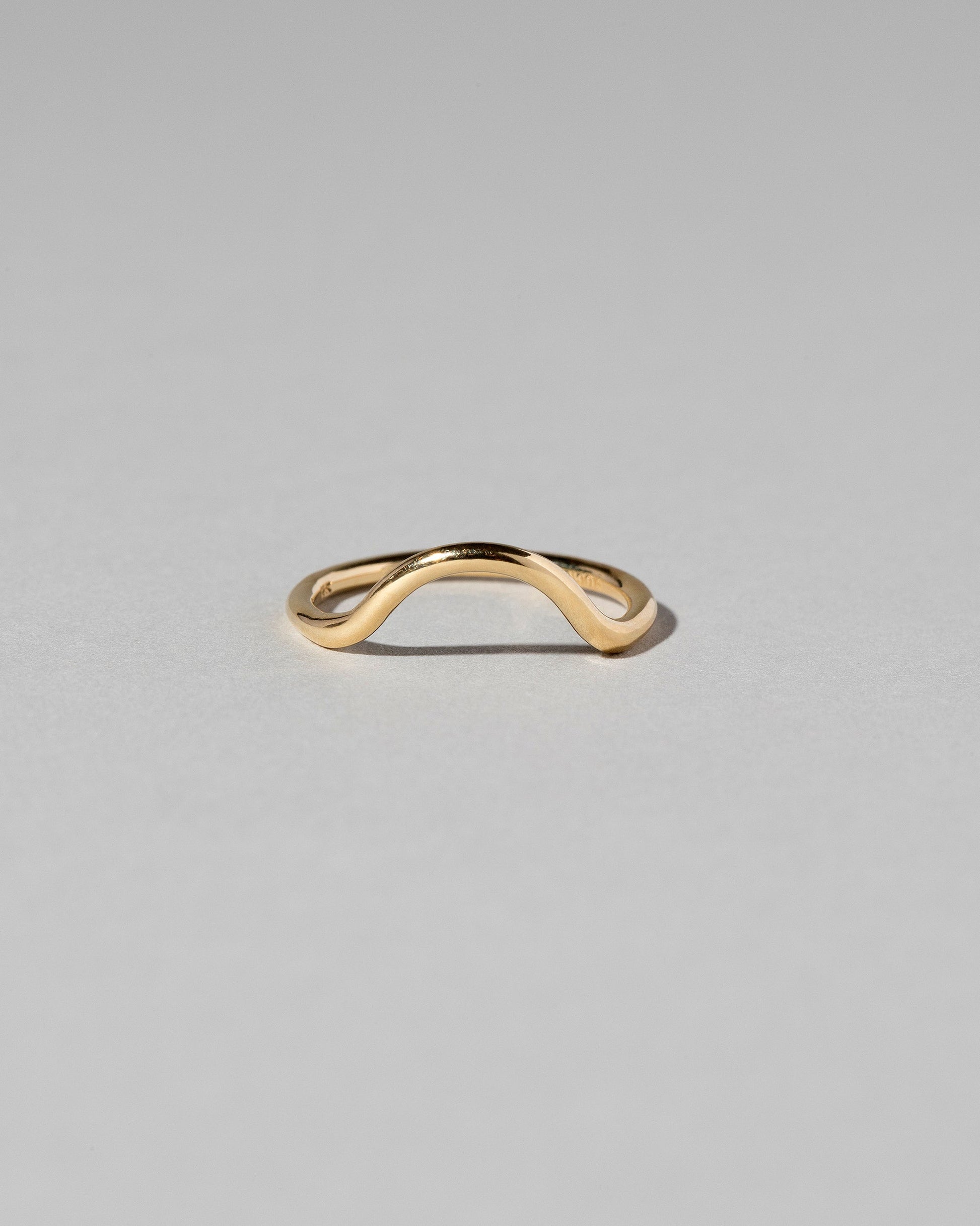 Gold Solid Round Wire Curve Band on light color background.